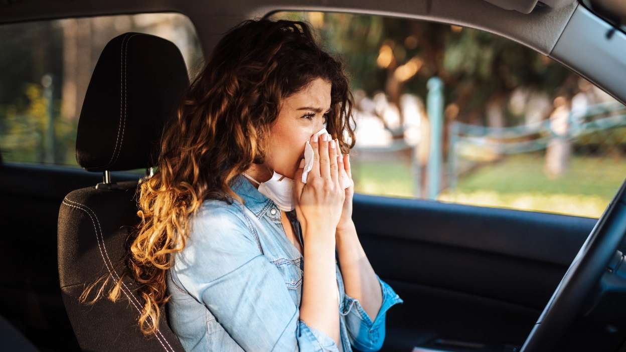 mulher a assoar o nariz dentro do carro
